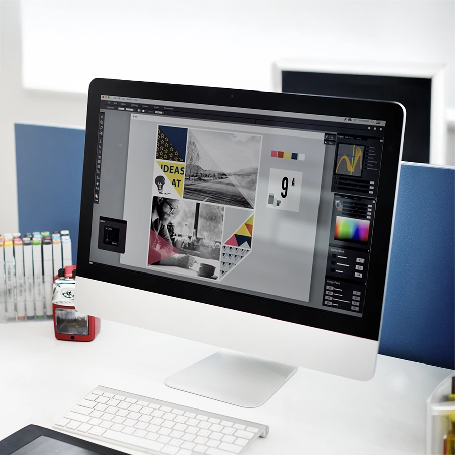 Desktop computer displaying a graphic design project with colorful branding elements, showcasing professional brand identity creation.